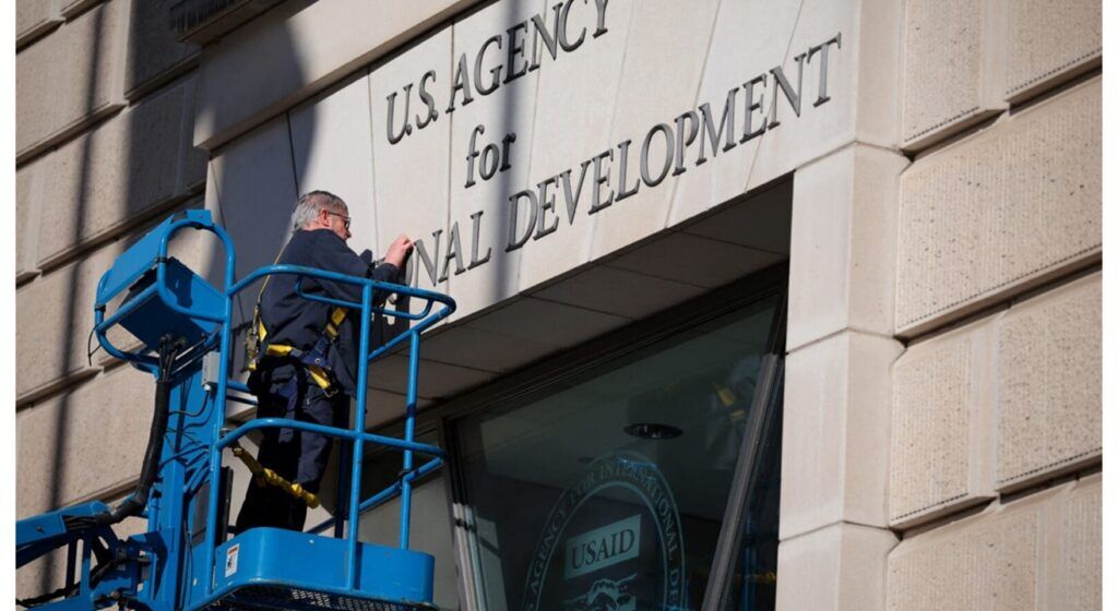 USAID sign being dismantled